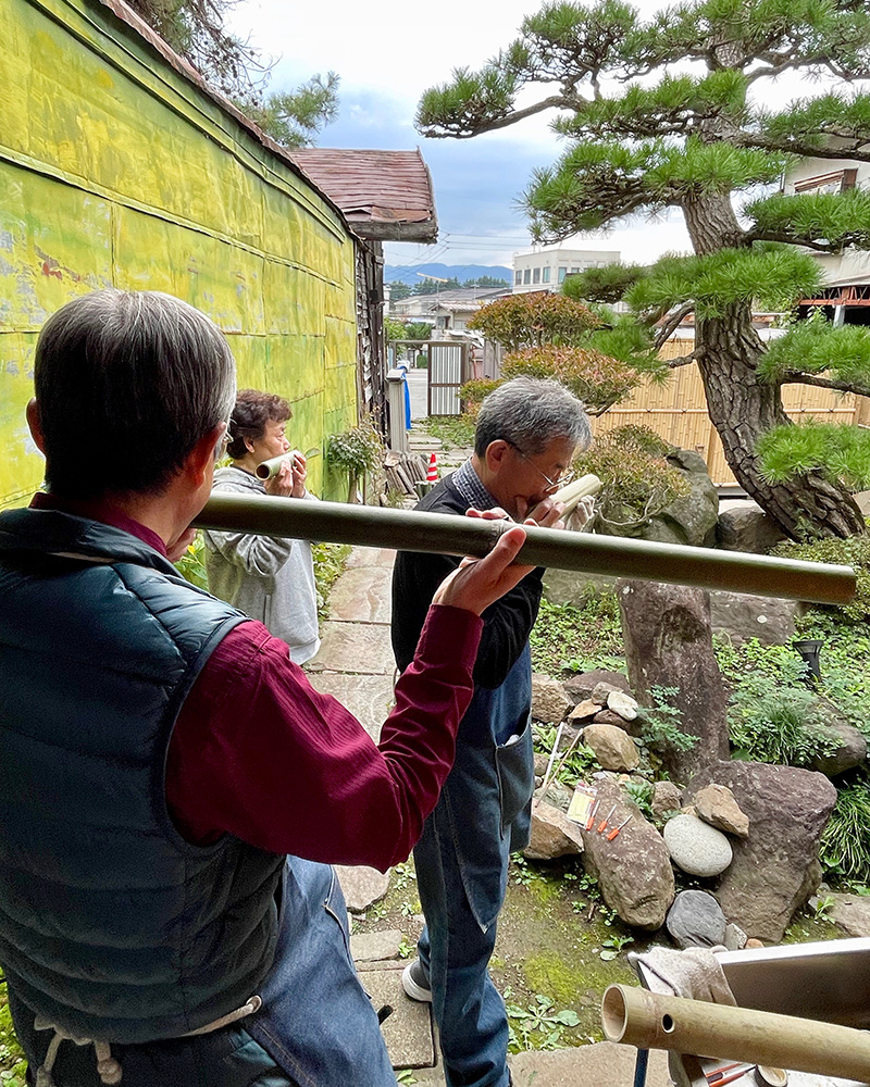 裏庭で竹法螺のワークショップをしていた写真