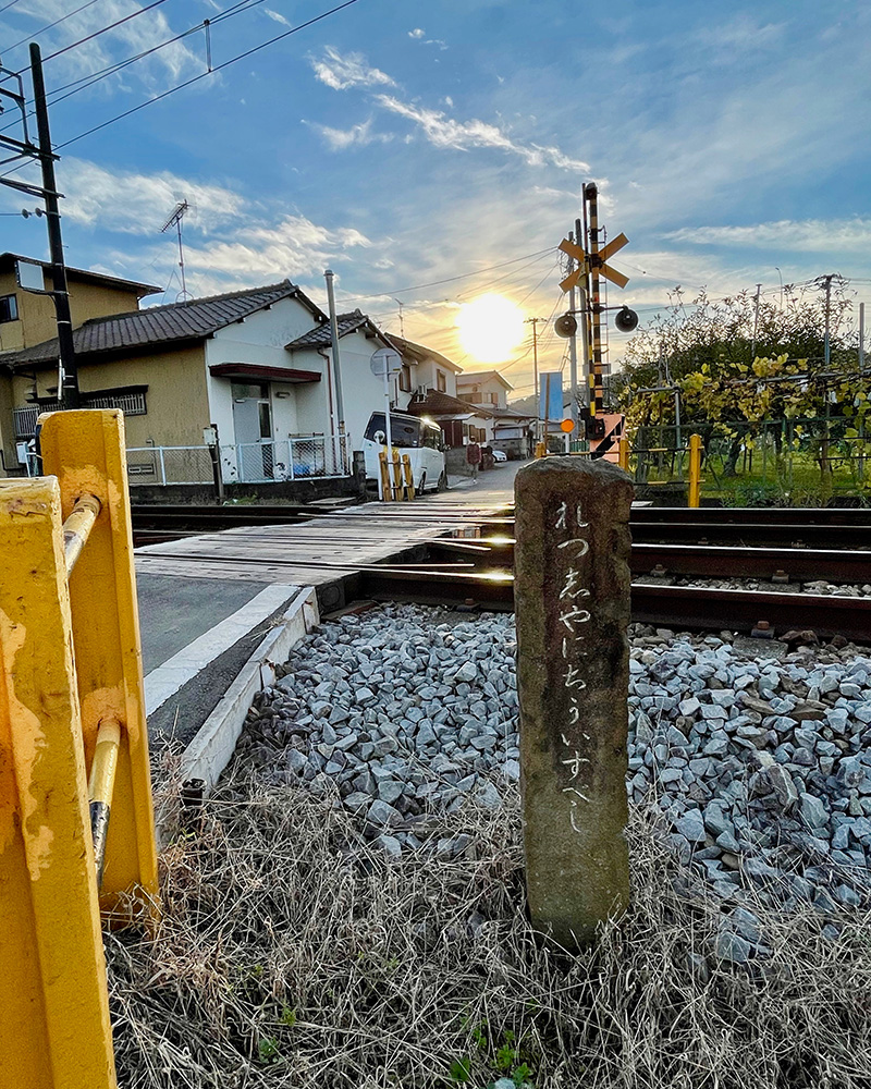 踏切に建つ石柱の写真