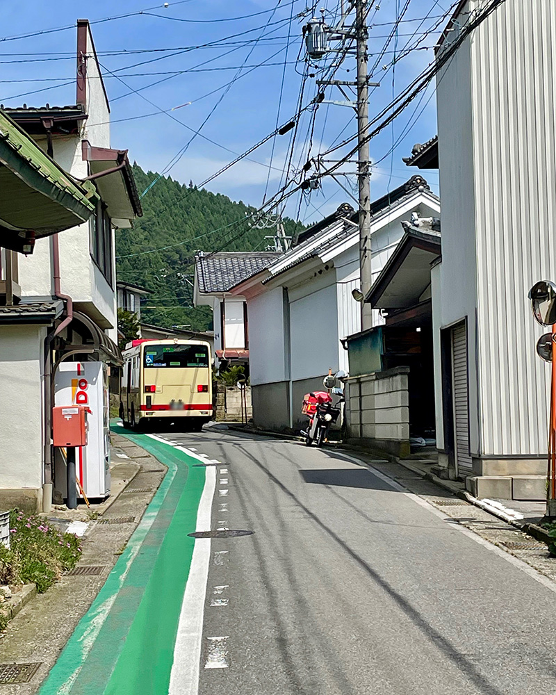 狭い道をバスが通る写真