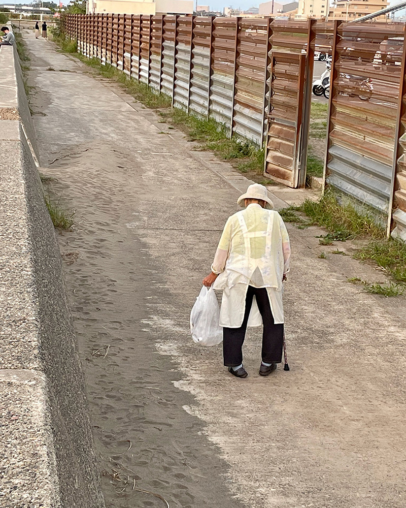 浜を綺麗にするおばあさんの写真