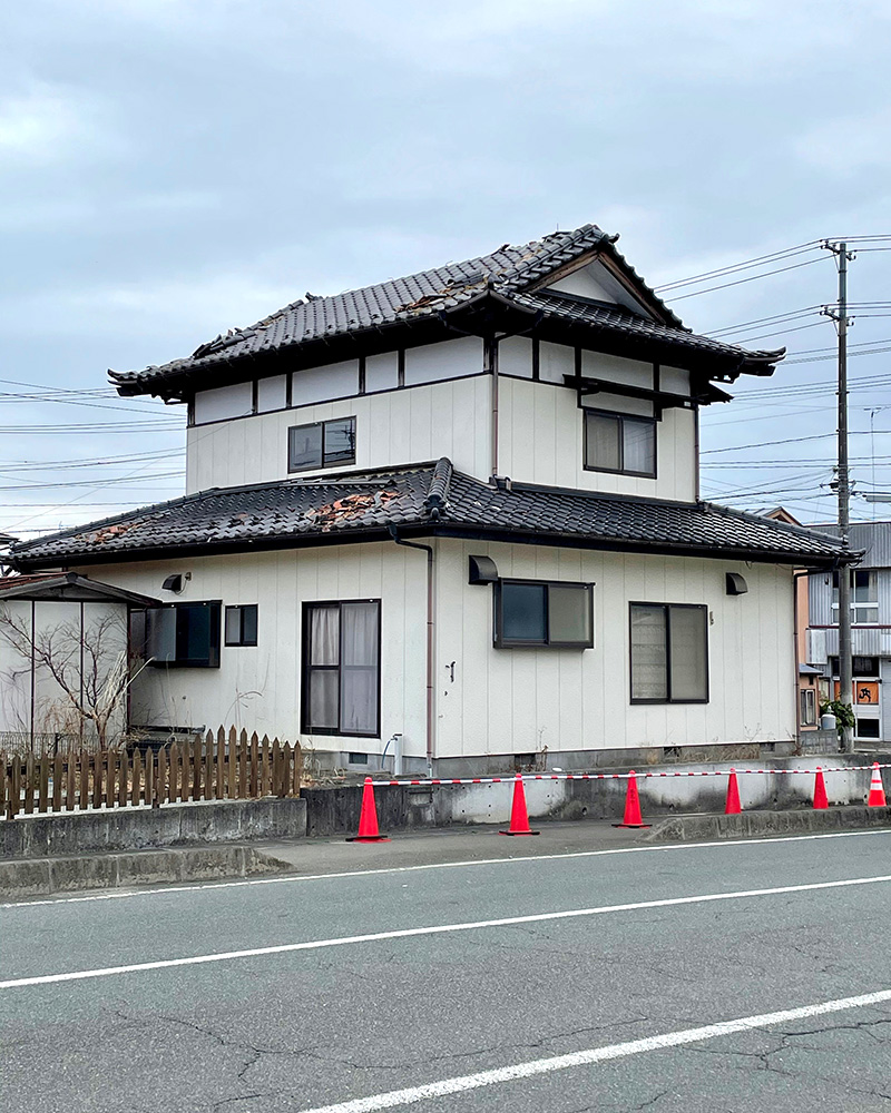 瓦屋根がくずれた民家の写真